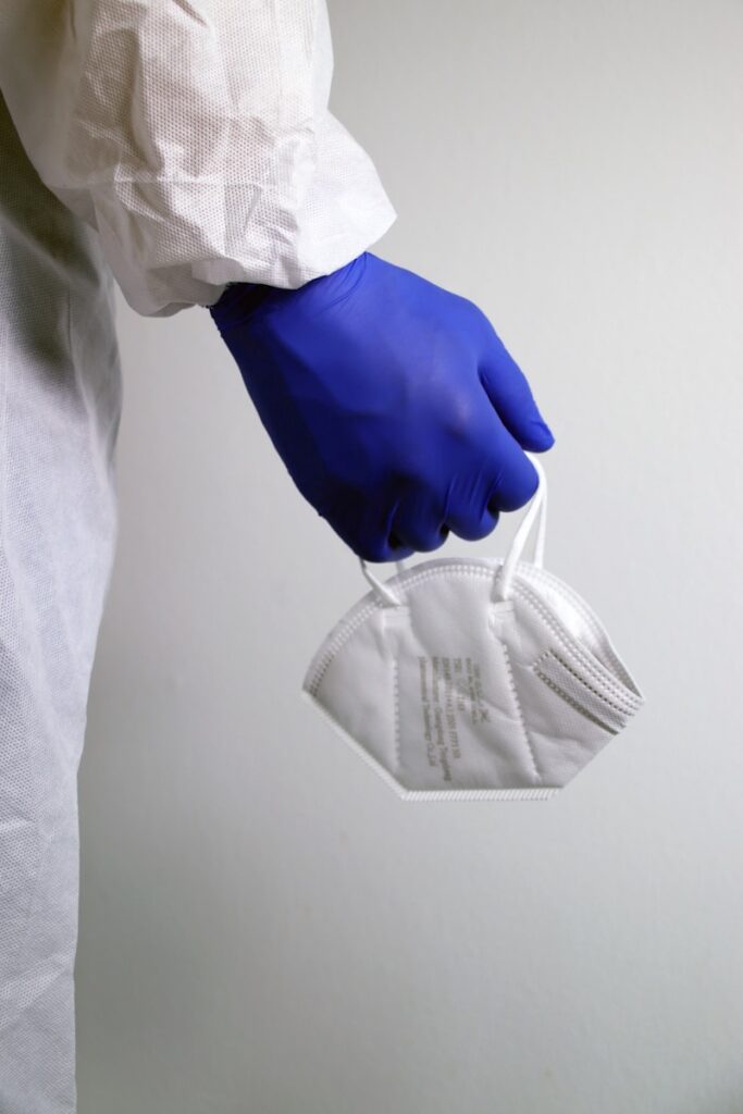 person in white dress shirt holding gray pants