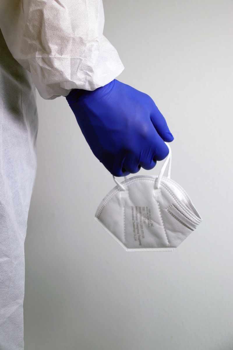person in white dress shirt holding gray pants