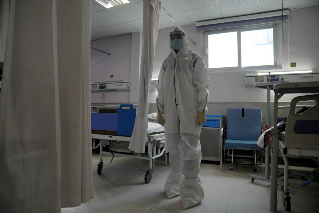 a man in a protective suit standing in a hospital